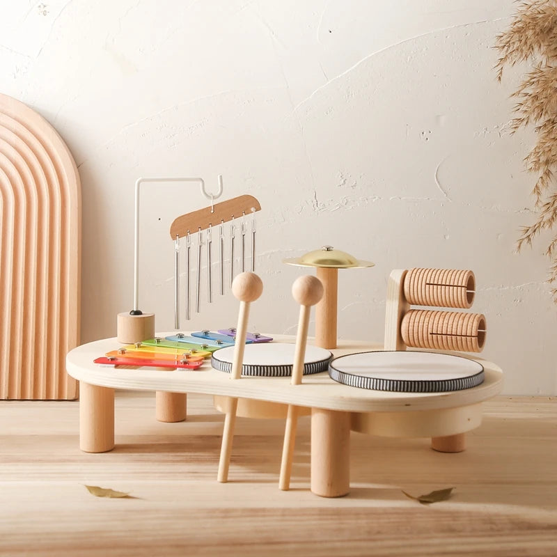 Children's wooden play set with various toys on a light wooden floor.