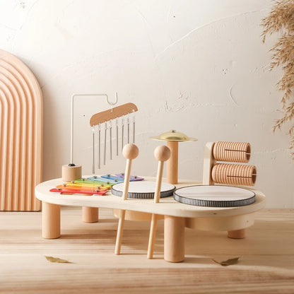 Children's wooden play set with various toys on a light wooden floor.
