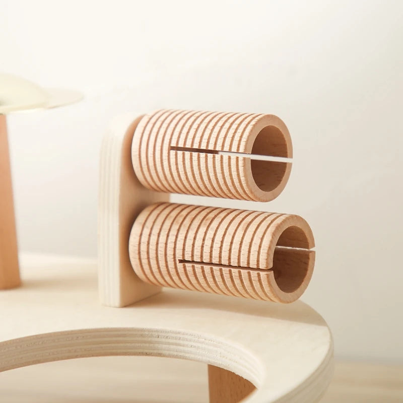 Wooden cat toy with cylindrical loops on a light background