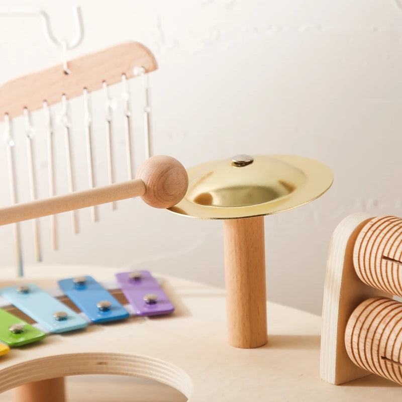 Wooden musical instruments including a xylophone and gong on a light surface.