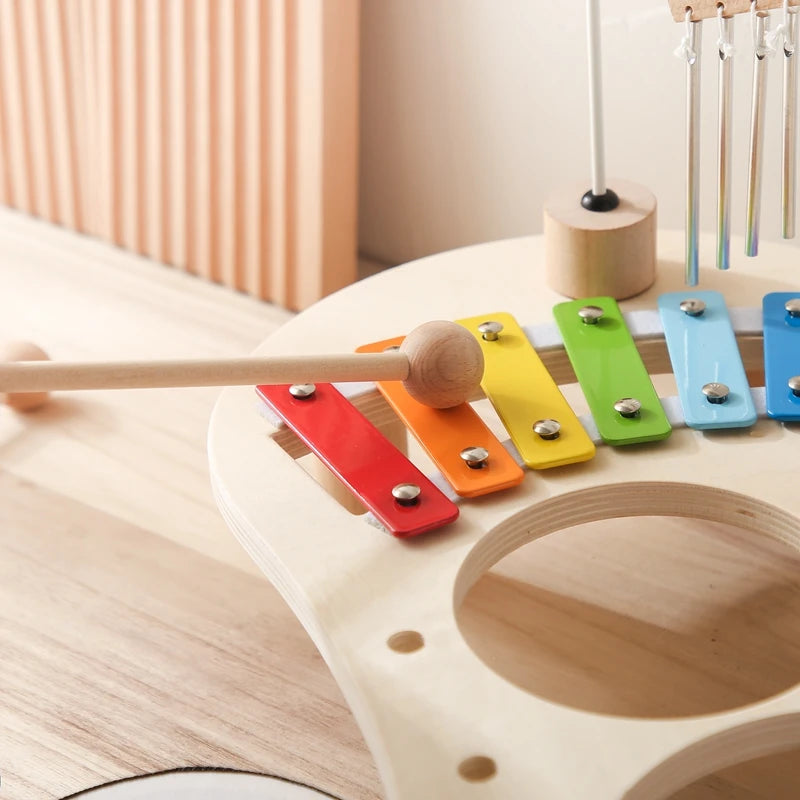 Colorful wooden xylophone with mallet on a light wooden surface